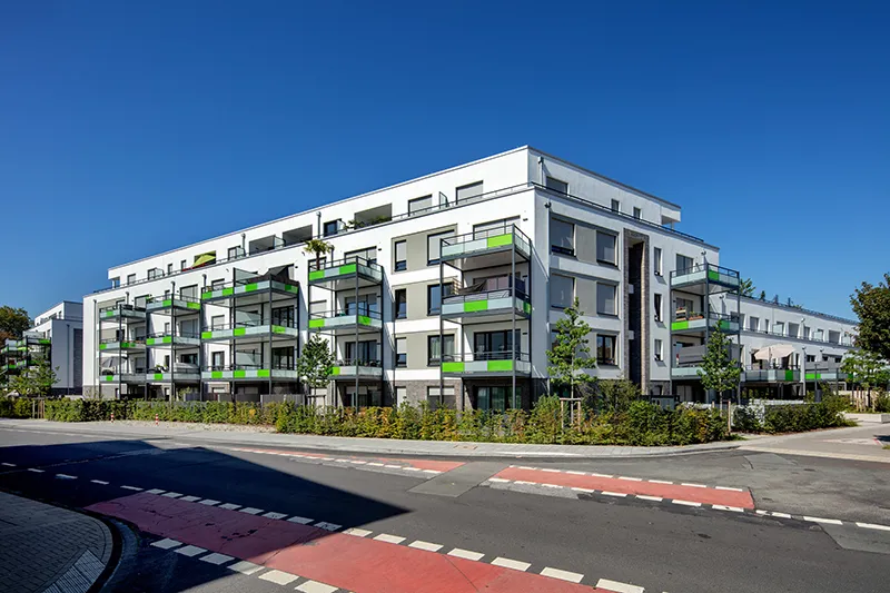 Modernes Wohnquartier mit Balkonen und grünen Fassadenelementen